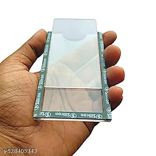 A hand holding a clear rectangular glass or quartz slide with green and white Silicon branded tape along its edges, against a plain white background.