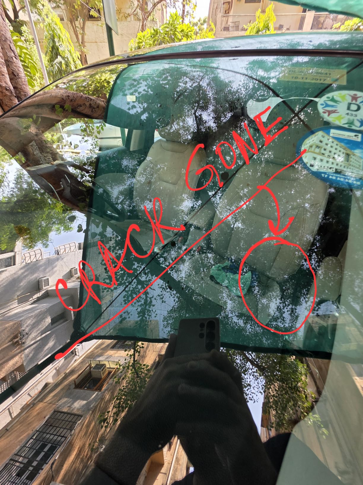 Car window with 'CRACK GONE' written on it, indicating a repair or inspection.