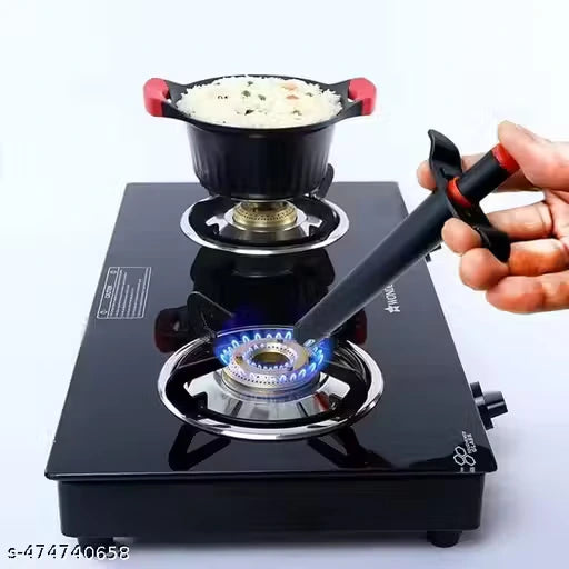 A black gas stove with a blue flame ignited, holding a black and red lighter held by a hand. A black pot with red handles sits on top of the stove, containing white rice with green and orange bits.
