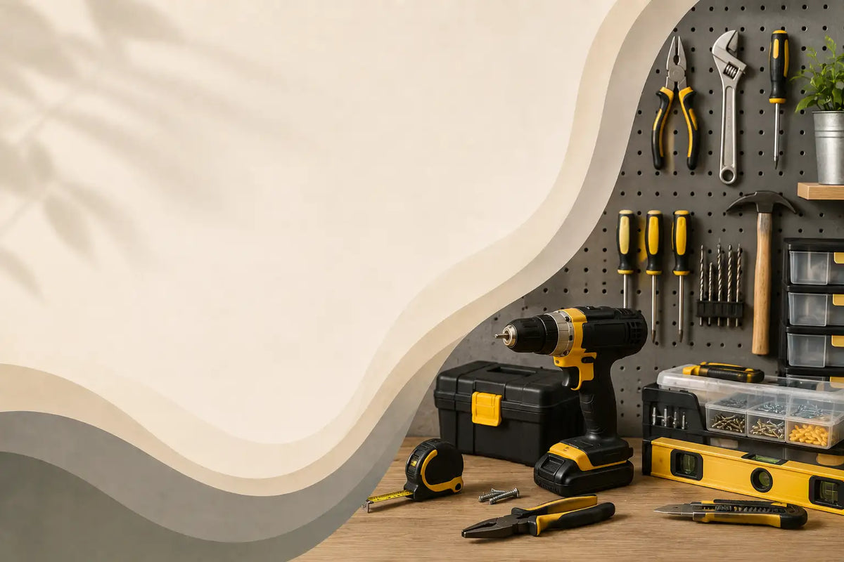A collection of yellow and black cordless power tools, including a drill, drill press, tape measure, and utility knife, arranged on a wooden workbench next to a yellow and black storage case. The tools are set against a gray pegboard with hanging hand tools like pliers, wrenches, and screwdrivers.