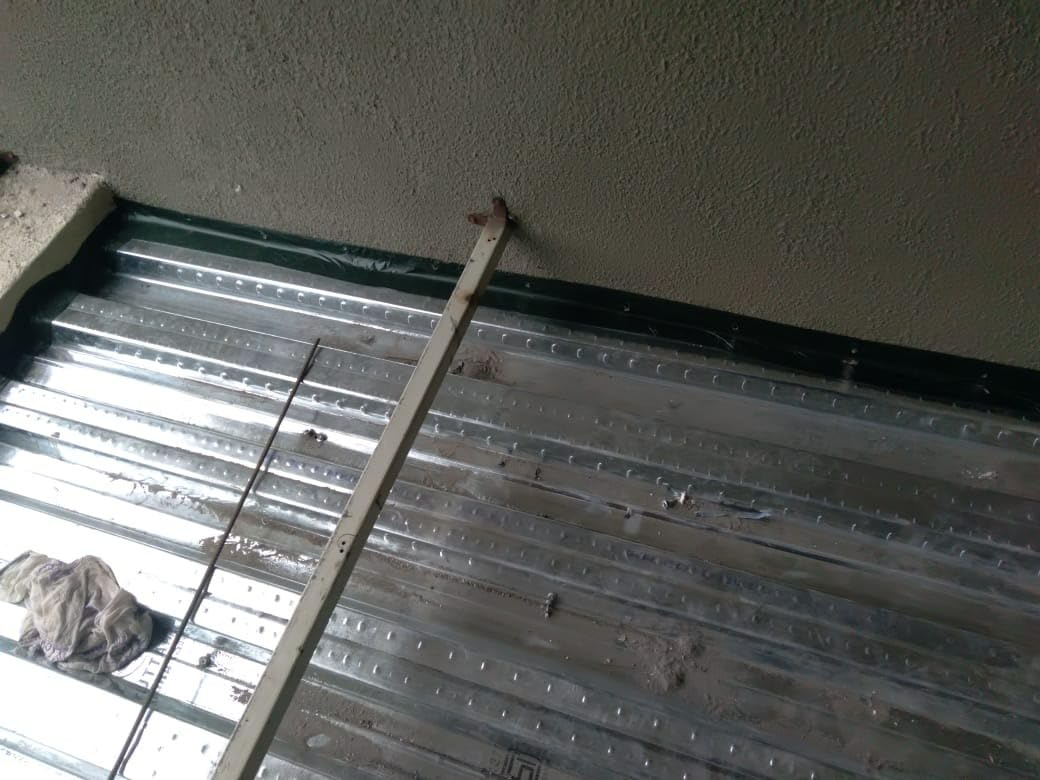 Metal sheet with a ruler for scale against a plain wall