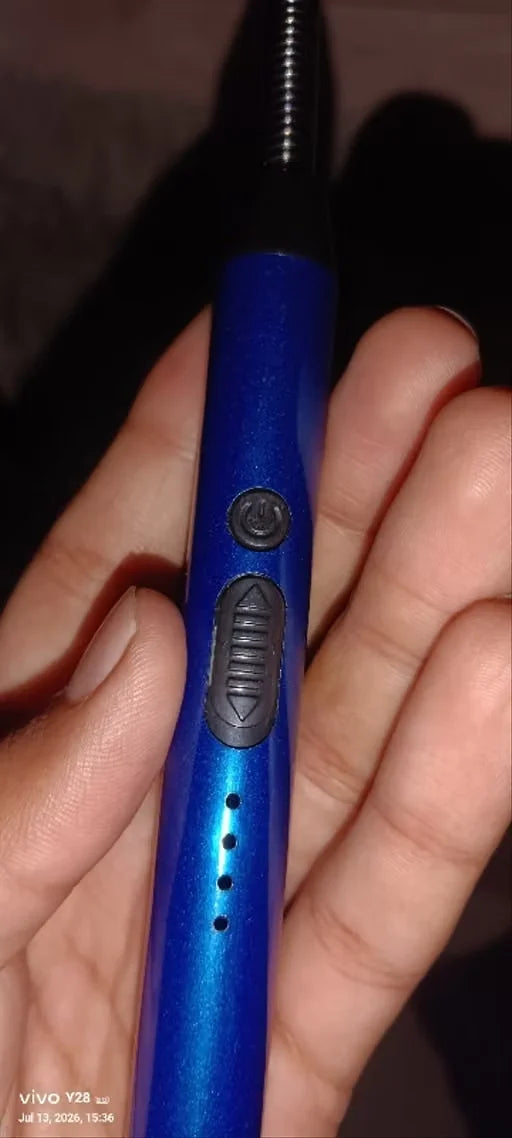 A close-up of a hand holding a blue electric hair trimmer with a black metal cord attachment. The trimmer has a metallic blue body with a black power button and a black trimmer head.